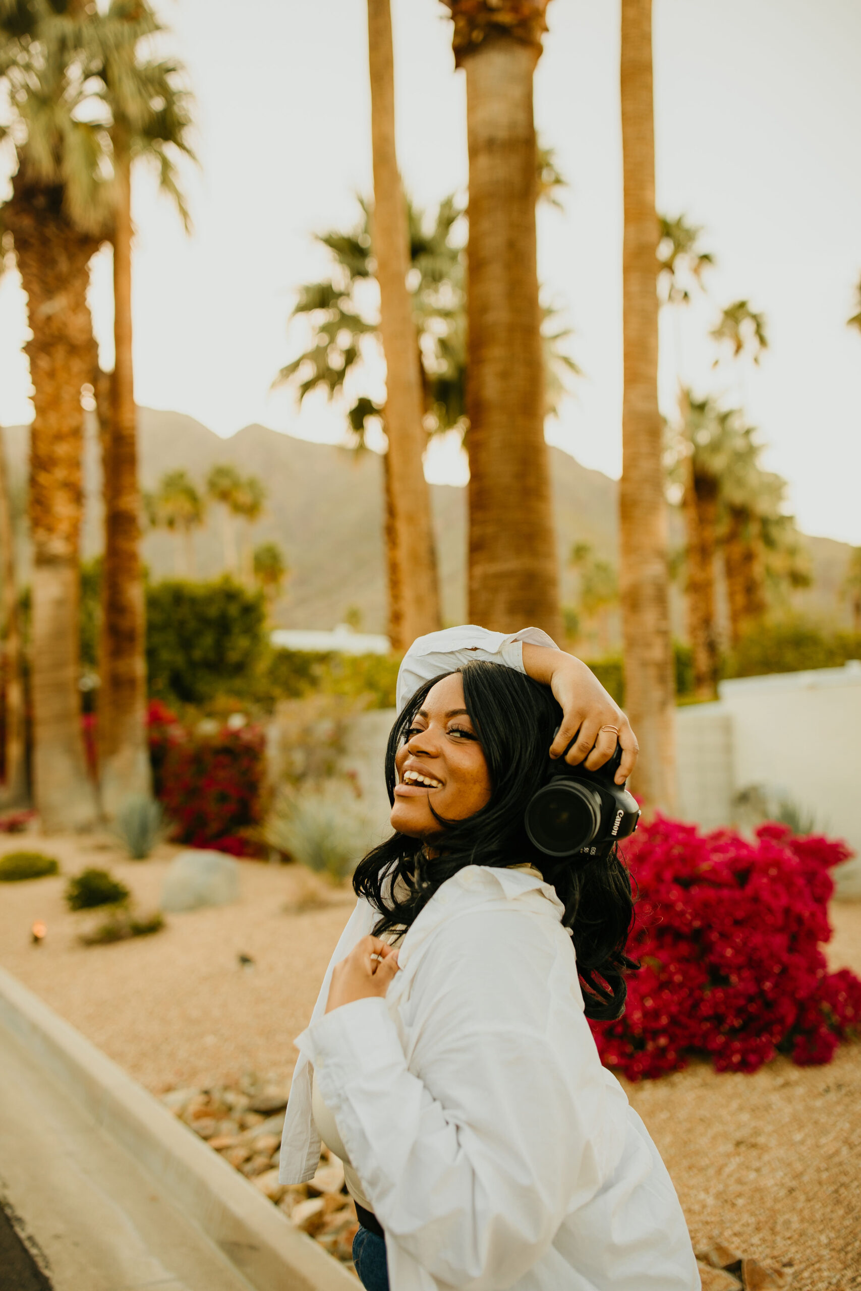 a girl holding a camera above her head